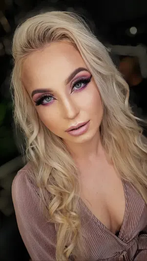  Nie wiem, kto jest na zdjęciu, ale mogę stworzyć opis: 

Piękna kobieta z długimi blond włosami i wyrazistym makijażem oczu, ubrana w elegancką bluzkę, zbliżenie twarzy. 