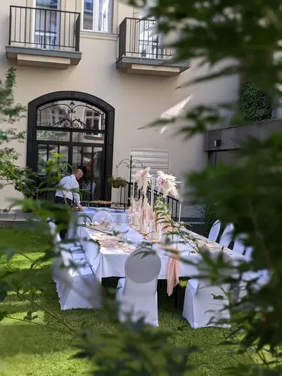  Stylowo udekorowany stół na zewnątrz, przygotowany na eleganckie przyjęcie w ogrodzie. 