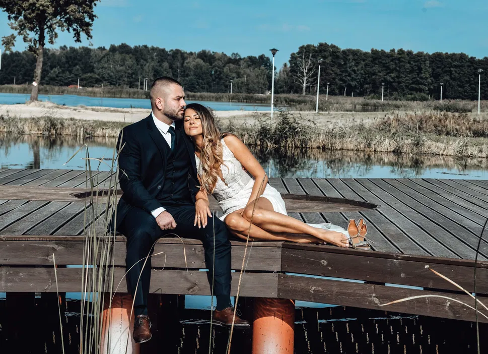 Para młoda na pomoście nad jeziorem w słoneczny dzień