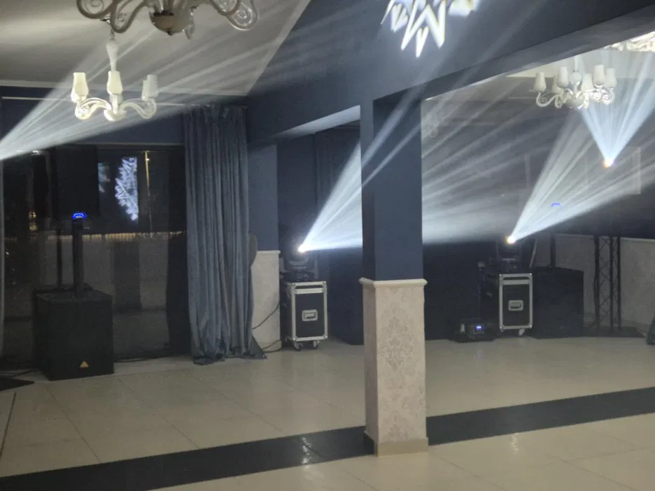 Sala bankietowa z dekoracyjnym oświetleniem, reflektory, ciemnoniebieskie ściany, nowoczesny wystrój wnętrza.