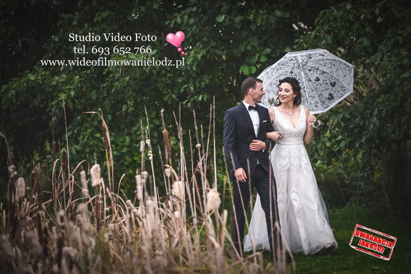  Para młoda spaceruje w ogrodzie, panna młoda trzyma parasol. 