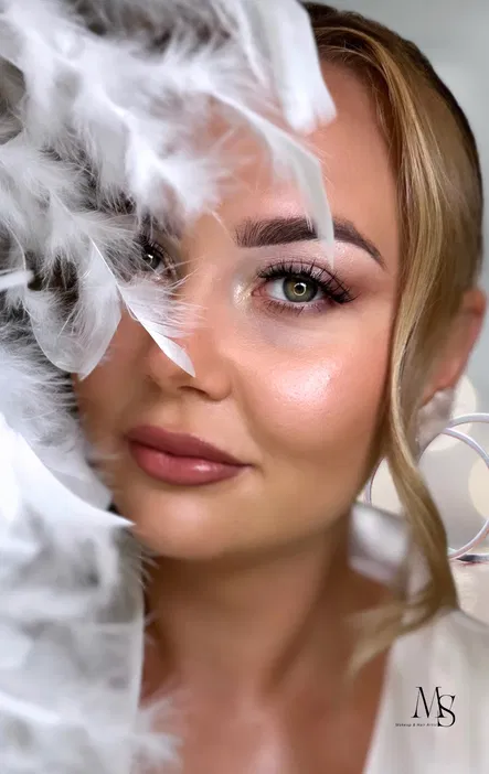 Portret kobiety z delikatnym makijażem, ozdobionej piórami – piękno i elegancja