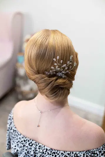  Elegancka fryzura ślubna z ozdobną spinką na blond włosach. 