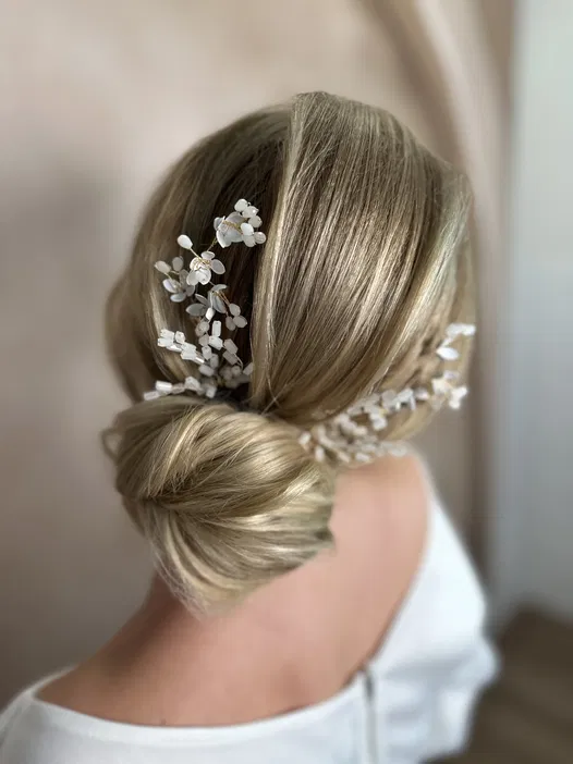 Upięcie ślubne z ozdobami; elegancka fryzura z blond włosów; wesele; delikatne kwiatowe akcenty we włosach.