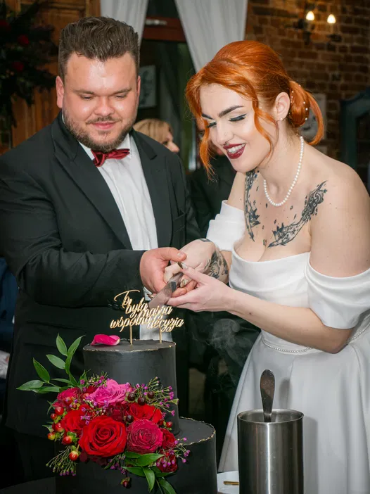 Para młoda krojąca tort weselny z kwiatową dekoracją, elegancki ślub, radość i świętowanie, ceremonia weselna.