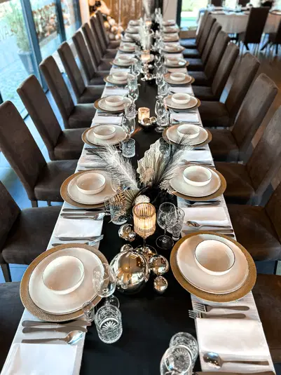  Luksusowa dekoracja stołu na przyjęcie weselne z eleganckimi talerzami, sztućcami i świecznikami, ozdobiona srebrnymi akcentami i białymi serwetkami, w stylu glamour. 