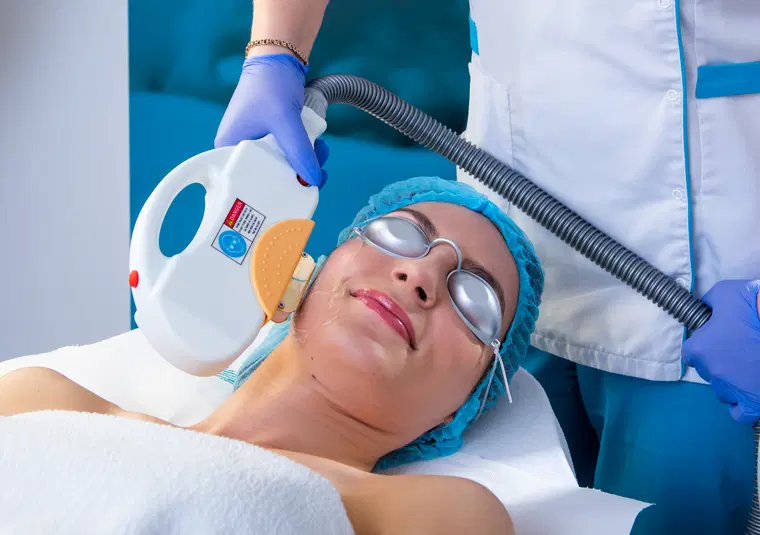  Zabieg kosmetyczny z użyciem lasera IPL na twarzy kobiety w klinice medycyny estetycznej. 