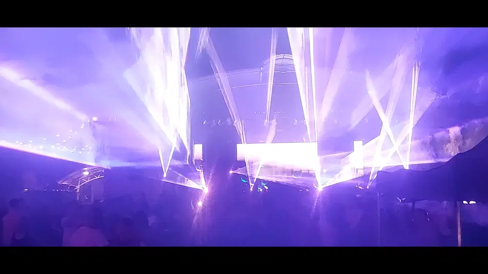  Koncert nocny z efektami świetlnymi, fioletowe światła i gęsta mgła na scenie. 