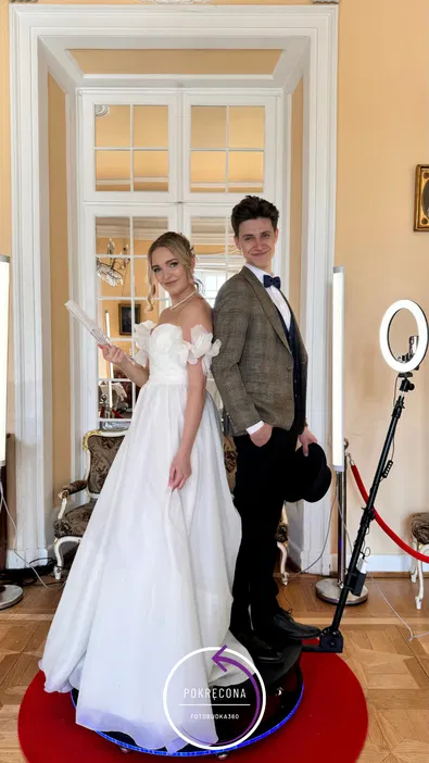 Para młoda pozująca w eleganckich strojach ślubnych na tle wnętrza z elementami vintage, fotobudka 360, wesele, klasyczna stylizacja, piękna suknia ślubna i garnitur.