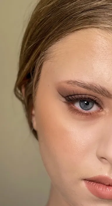 Zbliżenie na oko z doskonałym makijażem, perfekcyjnie wykonane kreski eyelinerem, długie rzęsy i naturalne brwi.