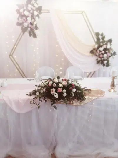  Dekoracja stołu weselnego z kwiatami róż i białymi obrusami, elegancka aranżacja ślubna. 