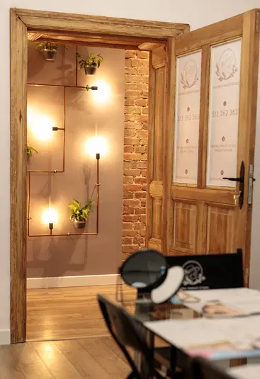  Stylowe wnętrze z ceglaną ścianą, roślinami wiszącymi i designerskimi lampami; eklektyczny wystrój wnętrz z elementami naturalnymi i nowoczesnym oświetleniem. 