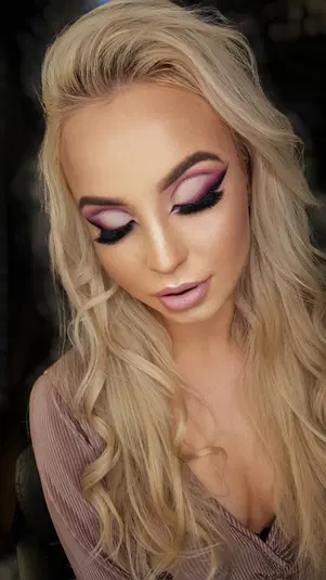  Blondynka z makijażem wieczorowym, różowe cienie do powiek, sztuczne rzęsy, elegancka stylizacja włosów. 