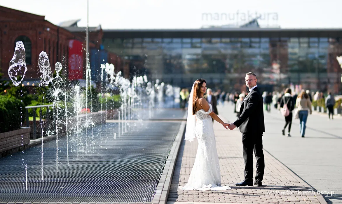 Para młoda pozująca przed fontanną w centrum handlowym Manufaktura w Łodzi.