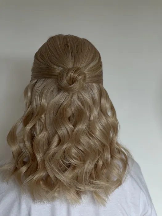 Blond włosy uczesane w półupięcie z falami i kokiem.