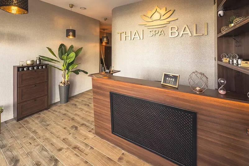  Recepcja w Thai Spa Bali, elegancki nowoczesny wystrój z roślinami i drewnianymi elementami, relaksująca atmosfera. 
