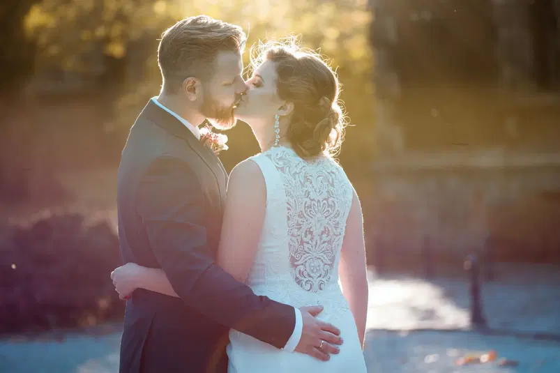  Para młoda podczas romantycznego pocałunku w promieniach zachodzącego słońca, elegancki strój ślubny, plenerowa sesja jesienna. 