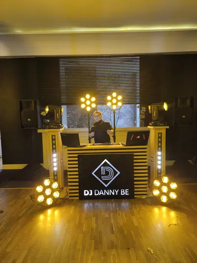  DJ podczas występu w klubie, profesjonalny sprzęt muzyczny, kolorowe oświetlenie sceniczne. 