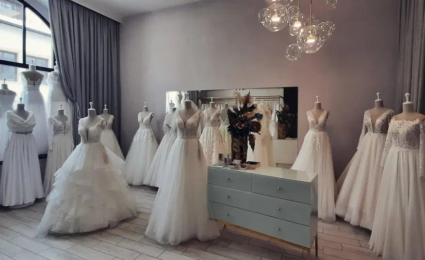  Sklep z sukniami ślubnymi, różne modele sukni na manekinach w eleganckim wnętrzu, idealne na ślub. 