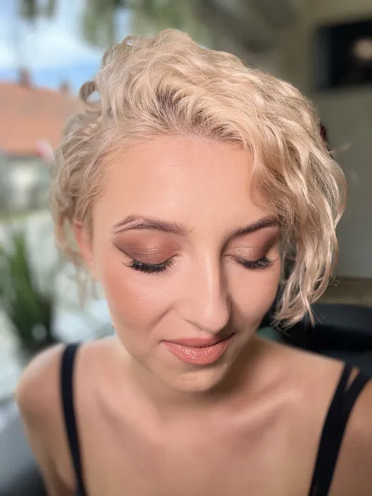 Kobieta z krótkimi blond włosami i delikatnym makijażem, naturalne światło, artystyczna sesja zdjęciowa