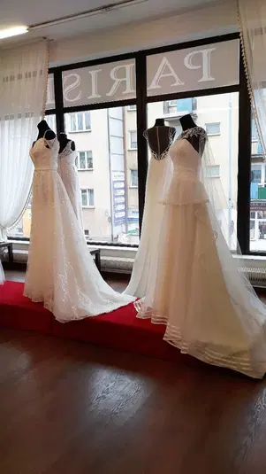  Sklep z sukniami ślubnymi, suknie na manekinach, eleganckie dodatki, salon mody ślubnej, wystawa ślubna. 