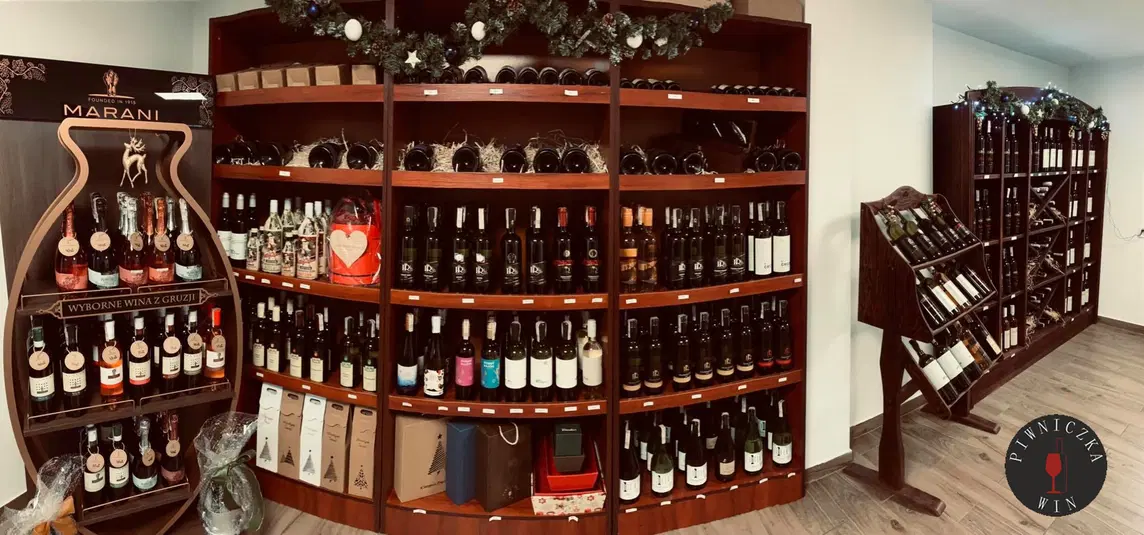  Sprzedaż win gruzińskich, eleganckie półki z butelkami wina w sklepie, dekoracje świąteczne, Piwniczka Win. 
