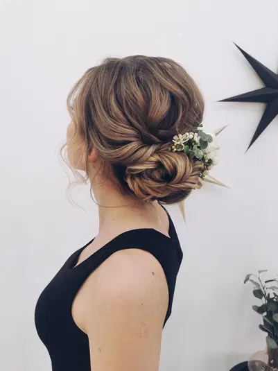  Kobieta z blond upięciem włosów ozdobionym białymi kwiatami, elegancka fryzura na specjalne okazje. 