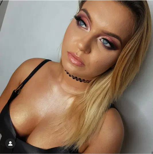  <p>Blondynka z pełnym makijażem glamour, ciemne oczy, różowe usta, czarna sukienka, choker</p> 