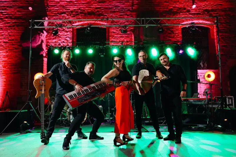  Zespół muzyczny na scenie, koncert, instrumenty muzyczne, gitara, keyboard, wokalistka, performance na żywo, światła sceniczne, scena muzyczna 