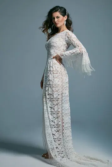  Kobieta w długiej koronkowej sukni wieczorowej, elegancka moda, białe ubranie z frędzlami, minimalistyczne tło. 