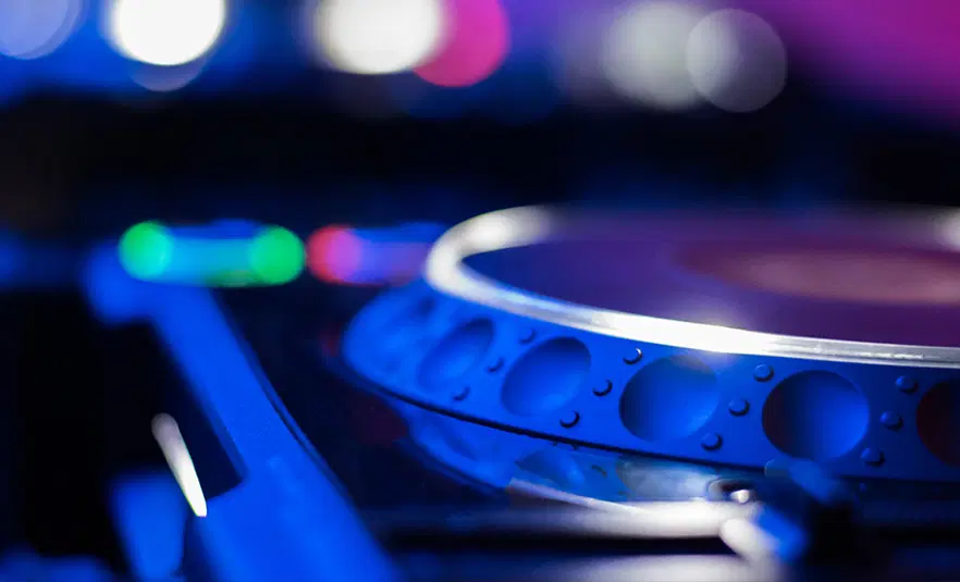  Profesjonalny sprzęt DJ-ski na imprezie muzycznej, kolorowe światła i klimat klubu nocnego. 