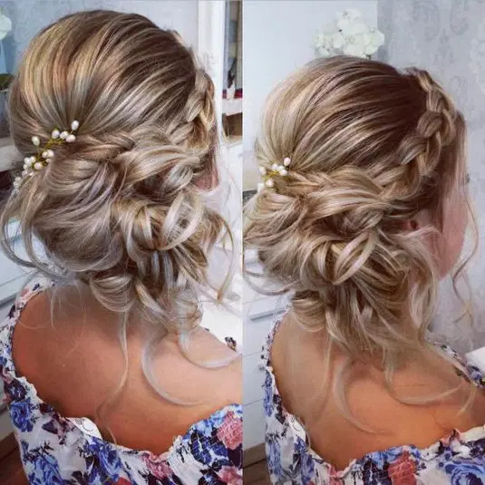  Romantyczna fryzura ślubna z blond włosów, ozdobiona warkoczem i perłowymi dodatkami, upięta w elegancki kok. 