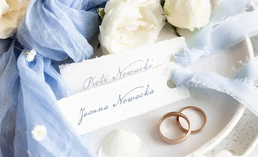  Czarno-białe eleganckie zaproszenia ślubne z kwiatowym motywem grafiki i kaligrafią na czarnym tle, z odręcznym napisem Eugenia oraz woskową pieczęcią. 