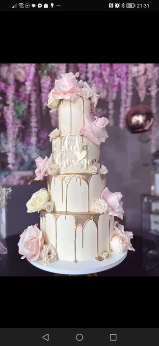 Trzypiętrowy tort weselny ozdobiony różami i złotym detalem, napis „Edyta i Grzegorz”, delikatne pastelowe kolory, elegancka dekoracja, kwiatowa aranżacja w tle.