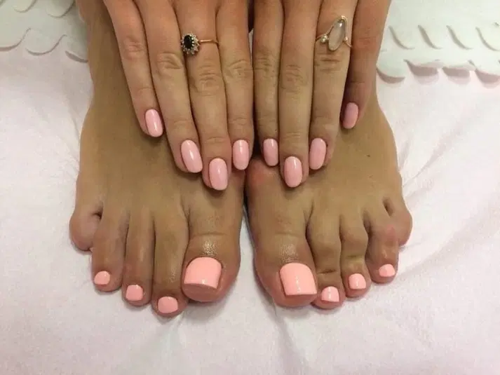  Różowy manicure i pedicure, zadbane paznokcie u rąk i stóp, eleganckie pierścionki, stylizacja paznokci. 
