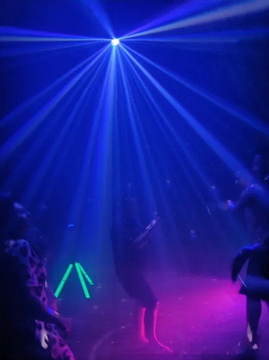 Taniec w klubie nocnym, kolorowe światła, atmosfera imprezy