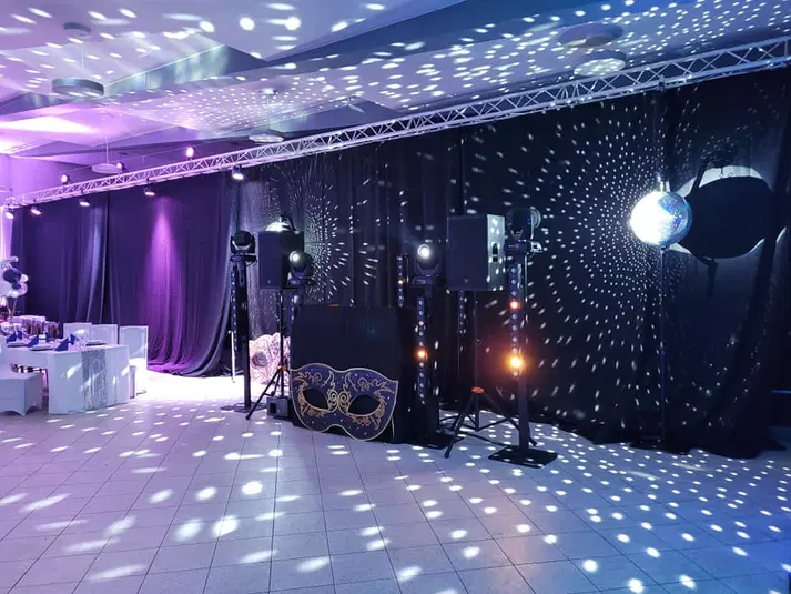  Sala bankietowa z dekoracją świetlną, kolorowe oświetlenie, maska karnawałowa, reflektory i lustro dyskotekowe, przygotowanie na event. 