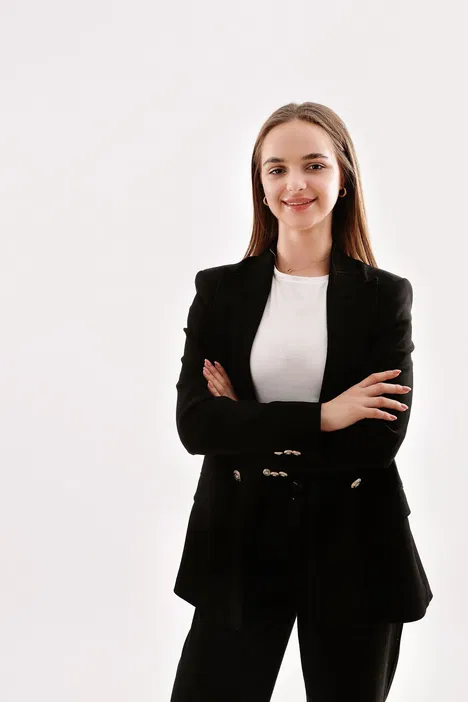 Businesswoman in a black blazer with crossed arms on a white background.