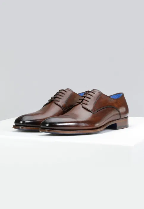 Eleganckie brązowe buty skórzane, klasyczne męskie obuwie wizytowe na białym tle.