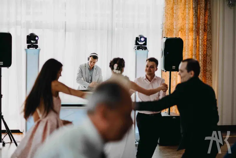  Taniec weselny przed DJ-em na eleganckim przyjęciu z oświetleniem i muzyką. 