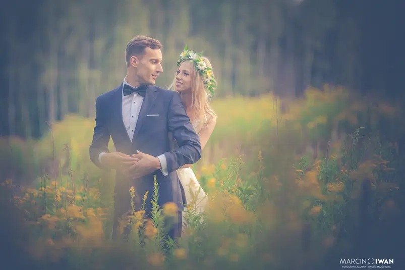  Romantyczna sesja ślubna pary w lesie, panna młoda w wianku z kwiatów, elegancko ubrany pan młody. 