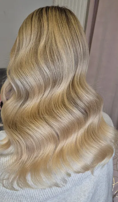 Blond fale na długich włosach, naturalna stylizacja, eleganckie i zdrowo wyglądające włosy.