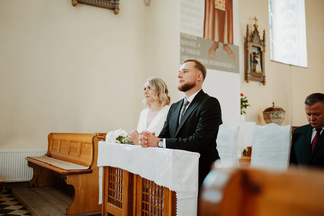 Para młoda przed ołtarzem w kościele, przygotowania do ceremonii ślubnej, eleganckie stroje, tradycyjna ceremonia weselna, biała suknia ślubna i garnitur.