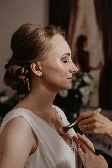  Panna młoda w białej sukni ślubnej, przygotowania do ceremonii, profesjonalny makijaż, fryzura ślubna, perfekcyjny wygląd na ślub, ceremonia zaślubin, emocje dnia ślubu, kobieta w dniu ślubu. 