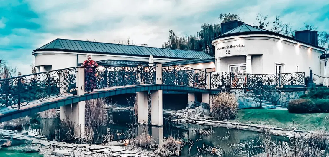  Widok na restaurację Borodino z ozdobnym mostkiem i stawem w ogrodzie, jesienna sceneria. 