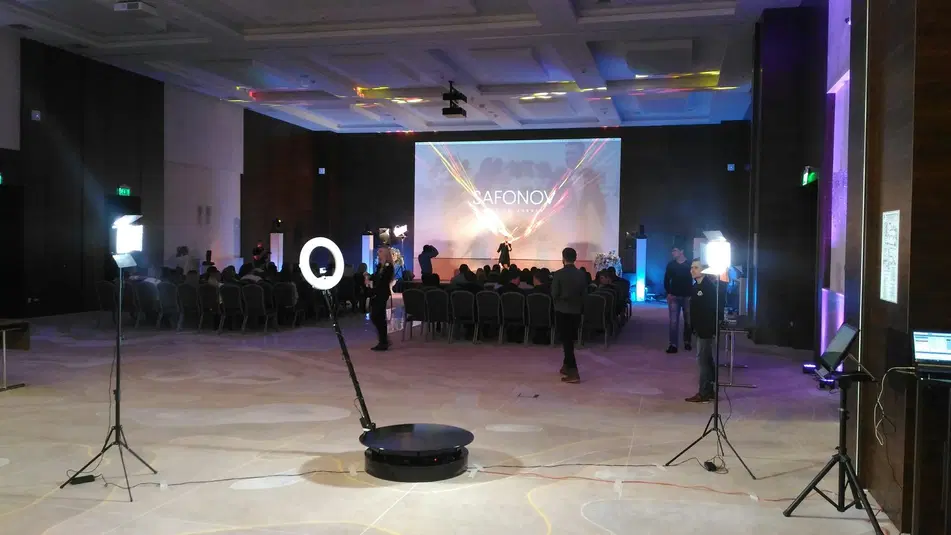  Wnętrze sali konferencyjnej z prezentacją multimedialną, sprzętem oświetleniowym i publicznością. 