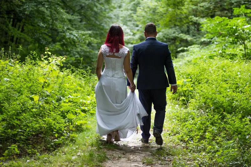  Para młoda spacerująca po leśnej ścieżce, natura, zielony las, romantyczny ślub na łonie natury, suknia ślubna i garnitur. 