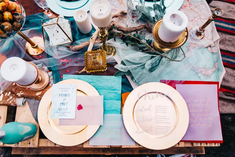  Romantyczna dekoracja stołu weselnego z menu i świecami, eleganckie talerze i kwiaty, boho styl. 