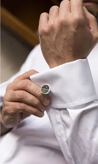 Mężczyzna zapinający spinki do mankietów na białej koszuli eleganckiej. 