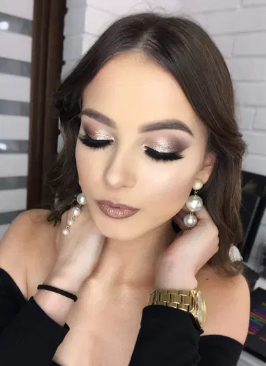  Kobieta z profesjonalnym makijażem oczu i perłowymi kolczykami, luksusowy zegarek, elegancki portret beauty. 